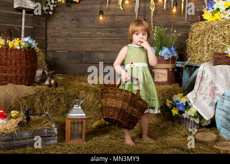 Little girl with a basket in her hand in a rustic interior Stock Photo