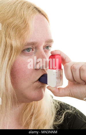 Young caucasian blonde female woman using asthma inhaler isolated on white background  Model Release: Yes. Property Release: No. Stock Photo