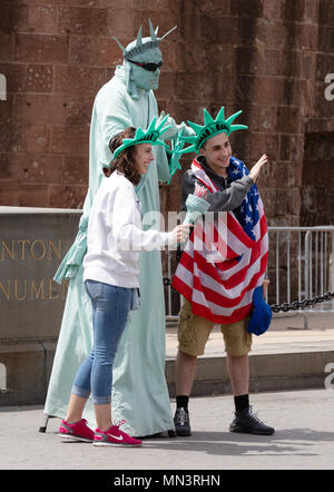 New York tourism - tourists posing for photos with a street performer in Statue of Liberty costume, downtown New York city, USA Stock Photo