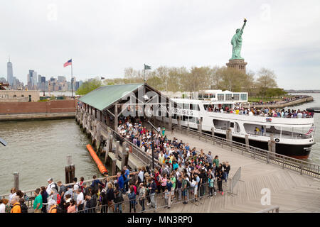 Tourists boarding a cruise boat at the dock on Liberty Island, with the Statue of Liberty, Liberty Island, New York city, USA Stock Photo