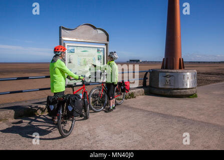 Southport, Merseyside. UK Weather. 14/05/2018. Bright sunny start to the day as Mark & Jenny check their route before setting off on a coast to coast cycle ride. The Trans Pennine Trail (TPT) is a route for walkers and cyclists. The Trail from coast-to-coast between Southport and Hornsea is 215 miles.  The Trans Pennine Trail is mapped and signed all the way, mainly traffic free and is surprisingly level considering the dramatic scenery along the way. Credit: MediaWorldImages/AlamyLiveNews. Stock Photo