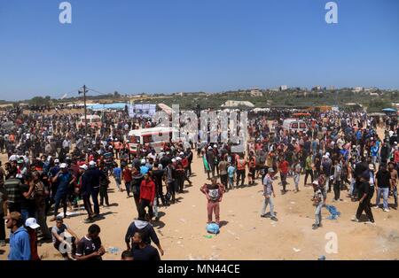 May 14, 2018 - Al-Bureij, Gaza Strip, Palestinian Territory - Palestinian protesters gather during clashes with Israeli security froces in a tent city protest where Palestinians demand the right to return to their homeland, on the occasion of the 70th anniversary of the ''Nakba'', and against U.S. embassy move to Jerusalem at Israel-Gaza border at the Israel-Gaza border, in al-Bureij in the center of Gaza Strip on May 14, 2018 Credit: Mahmoud Khattab/APA Images/ZUMA Wire/Alamy Live News Stock Photo