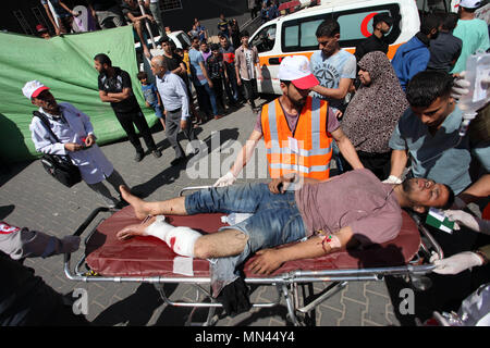 Gaza City, Gaza Strip, Palestinian Territory. 14th May, 2018. A Palestinian man who was wounded during clashes between Palestinian protesters and Israeli security forces at the Israel-Gaza border, in a tent city protest where Palestinians demand the right to return to their homeland, on the occasion of the 70th anniversary of the ''Nakba'', and against U.S. embassy move to Jerusalem, is carried on stretcher at hospital in Gaza city on May 14, 2018 Credit: Mahmoud Ajour/APA Images/ZUMA Wire/Alamy Live News Stock Photo