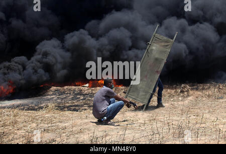 Khan Younis, Gaza Strip, Palestinian Territory. 14th May, 2018. Palestinian protesters gather during clashes with Israeli security froces in a tent city protest where Palestinians demand the right to return to their homeland, on the occasion of the 70th anniversary of the ''Nakba'', and against U.S. embassy move to Jerusalem at the Israel-Gaza border, in Khan Younis in the southern Gaza Strip on May 14, 2018 Credit: Ashraf Amra/APA Images/ZUMA Wire/Alamy Live News Stock Photo