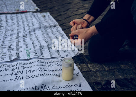 Berlin, Germany. 14th may 2018. A woman lighting up a candle in support of Palestine. Hundreds of demonstrators gathering in Berlin to protest the violent actions that has been taken by the Israeli military in Gaza which has led to at least 50 dead. Credit: SOPA Images Limited/Alamy Live News Stock Photo