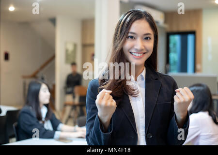 Asian businesswomen Success and winning concept - happy team with raised up hands celebrating the breakthrough and achievements Stock Photo
