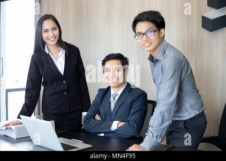 Asian businessmen and group using notebook for business partners discussing documents and ideas at meeting and business women smiling happy for workin Stock Photo