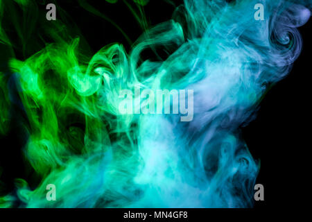 Dense multicolored smoke of   blue and green colors on a white isolated background. Background of smoke vape Stock Photo