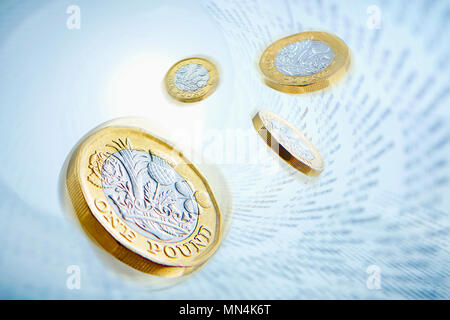 One pound coins surrounded by stock market data Stock Photo