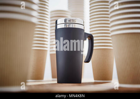 Insulated drink container surrounded by disposable coffee cups Stock Photo