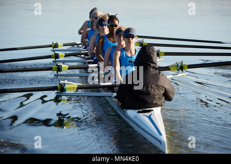 Female rowers rowing scull on lake Stock Photo