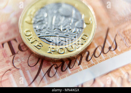 Close up one pound coin on ten pound note Stock Photo