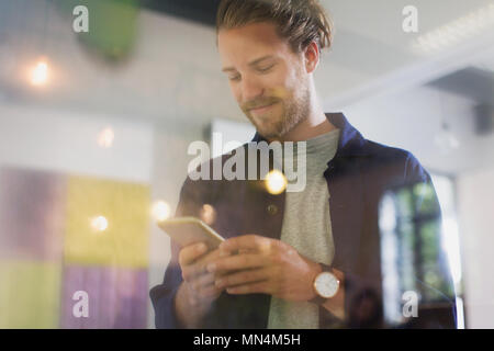 Smiling businessman texting with smart phone Stock Photo