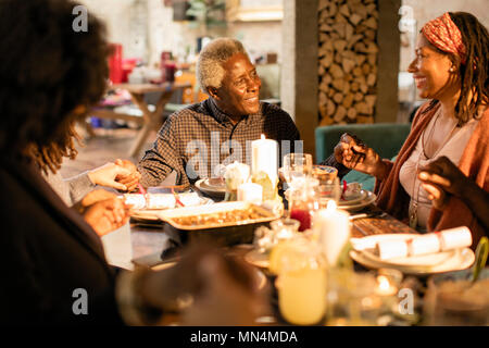 Multi-generation family holding hands, praying at Christmas dinner Stock Photo