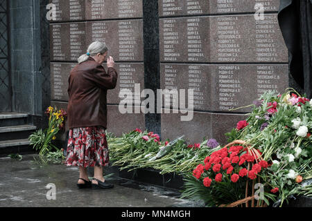 An elderly Transnistrias woman standing in front of the Memorial of Glory a multi-part monument commemorating the veterans and the dead of the Great Patriotic War (World War II), the Soviet-Afghan War, and the 1990-1992 Transnistria War located on Suvorov Square in Tiraspol the capital and administrative centre of the internationally recognized borders of Moldova under de facto control of the unrecognized Pridnestrovian Moldavian Republic also called Transnistria (PMR) since 1992. Stock Photo