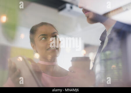 Business people with coffee talking, using digital tablet Stock Photo