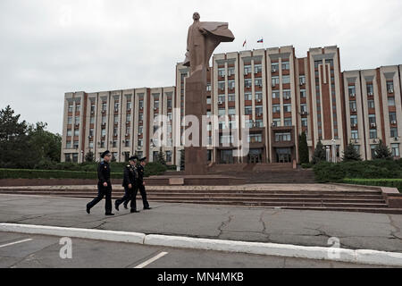 Officers of the Armed Forces of the Pridnestrovian Moldavian Republic of the semi-recognised state of Transnistria walk past the statue of Vladimir Lenin in front of the parliament building in the center of Tiraspol the capital and administrative centre of the internationally recognized borders of Moldova under de facto control of the unrecognized Pridnestrovian Moldavian Republic also called Transnistria (PMR) since 1992. Stock Photo