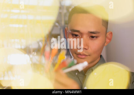 Focused IT technician examining multicolor connection plugs Stock Photo