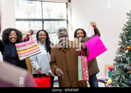 Enthusiastic multi-generation family arriving with Christmas gifts Stock Photo