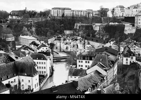 a view of Alzette River passing through the Grund Quarter of Luxembourg City, Luxembourg, with its typical houses with black slate roofs, in black and Stock Photo