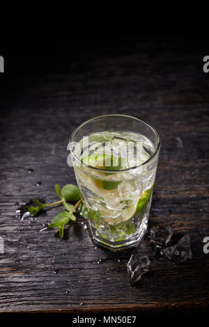 From above shot of mojito cocktail with ice and mint in glass on dark background Stock Photo