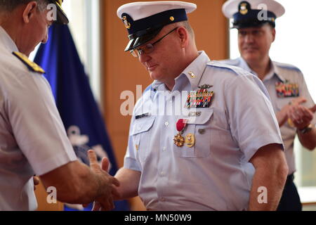 Master Chief Petty Officer Charles “Rob” Bushey is congratulated by Coast Guard Atlantic Area Commander Vice Adm. Karl L. Schultz and presented the Legion of Merit Medal, during the Command Master Chief Change of the Watch ceremony May 8, 2018 in Norfolk, Virginia. The Legion of Merit is awarded to any member of the Armed Forces of the United States or a friendly foreign nation who has distinguished himself or herself by exceptionally meritorious conduct in the performance of outstanding services and achievements. U.S. Coast Guard photo by Petty Officer 2nd Class Adam Stanton. Stock Photo