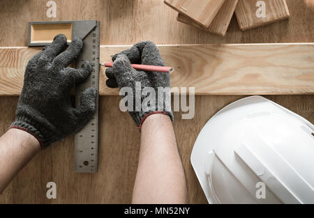 top view of carpenter measuring and writing on wood with copy space background Stock Photo