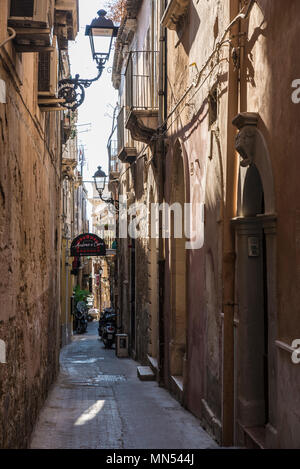 Siracusa, Italy - August 17, 2017: Narrow street in the old town of the historic village of Siracusa in Sicily, Italy Stock Photo