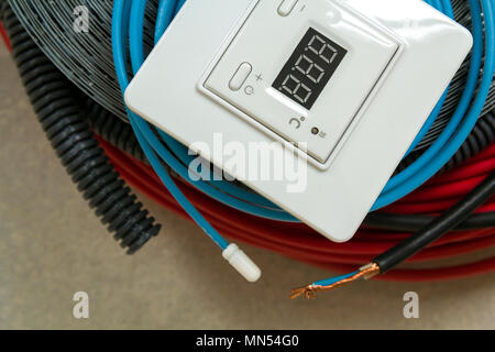 Heating floor system wires, cables and control panel. Renovation and construction concept. Comfort house. Stock Photo