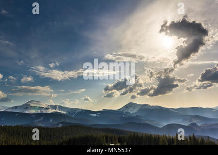 Beautiful fantastic view of blue sky with bright white clouds in mysterious shape of question over magnificent mountain rage with snow covered tops an Stock Photo