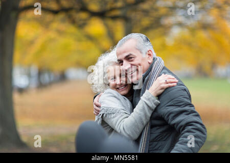 Happy senior couple hugging in autumn park Stock Photo