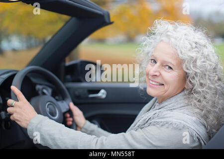 Portrait smiling senior woman driving convertible Stock Photo