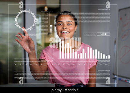 Smiling, enthusiastic businesswoman using futuristic hologram computer Stock Photo