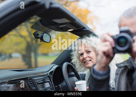 Senior couple using digital camera in convertible Stock Photo