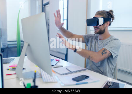 Male computer programmer programming virtual reality simulator glasses at computer in office Stock Photo