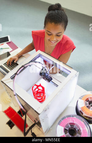 Smiling female designer watching 3D printer in office Stock Photo