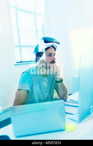 Focused computer programmer programming virtual reality simulator glasses Stock Photo