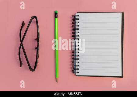 Education notebook pencil and eyeglasses on bright pink background Stock Photo
