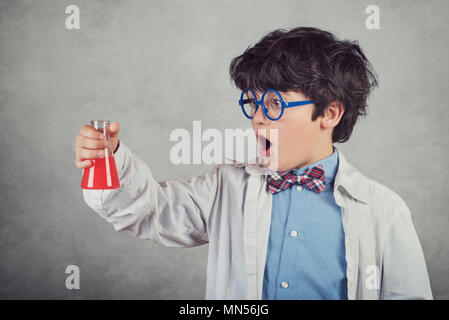 boy is making science experiments on gray background Stock Photo