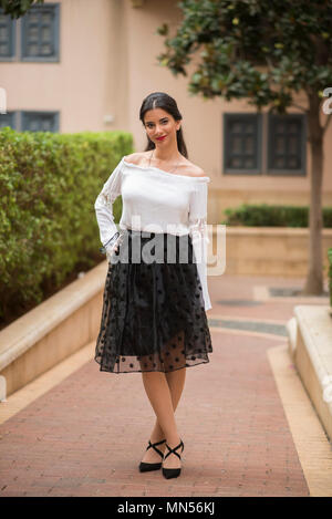 Beautiful young woman standing outdoors smiling Stock Photo