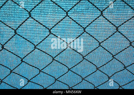 Background blue tarpaulin and chain link fence Stock Photo
