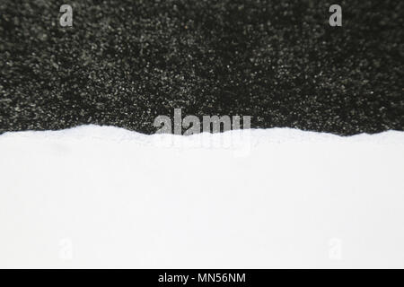Torn White Paper on Rough Dark Textured background Stock Photo