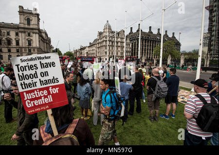 Protesters display placard during the protest for Grenfell tragedy in front of the British Parliament. Protesters gathered in Parliament square in central London to demand justice for the victims of the Grenfell tower fire last year. Stock Photo