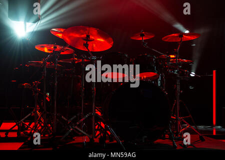 A kit of drums and a microphones on an empty stage in blue smoke before the concert Stock Photo