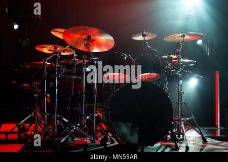 A kit of drums and a microphones on an empty stage in blue smoke before the concert Stock Photo