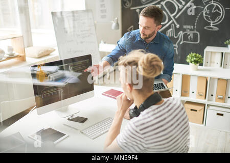 Portrait of two contemporary young men in casual wear coding using computer collaborating  on startup project in modern office, copy space Stock Photo