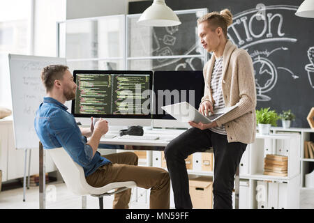 Portrait of two contemporary web developers writing code for program collaborating on startup project in modern office, copy space Stock Photo