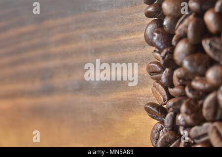 Coffee beans lie on the right on a light wooden background. Stock Photo