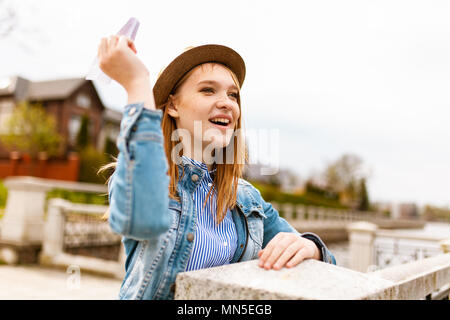 Young beautiful red haired girl throwing a paper plane Stock Photo