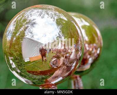 Celle, Lower Saxony, Germany, April 28, 2018: Reflective metal balls with the photographer's reflection in the foreground, blurry background Stock Photo